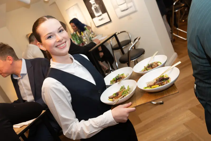 Servicekraft serviert Teller beim Flying Dinner von Kunst & Kulinarik 2026