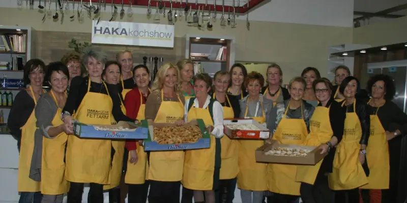 Kiwanis-Damen in gelben Schürzen mit Blechen voller Gebäck